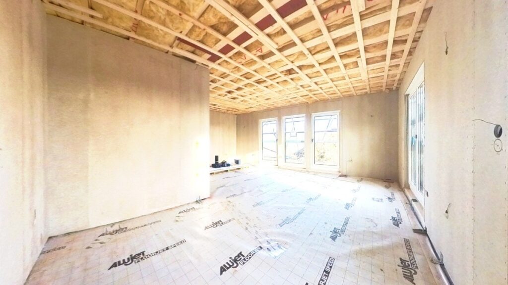 Blick von der Küche in den Wohnbereich mit Zugang zur zukünftigen Terrasse