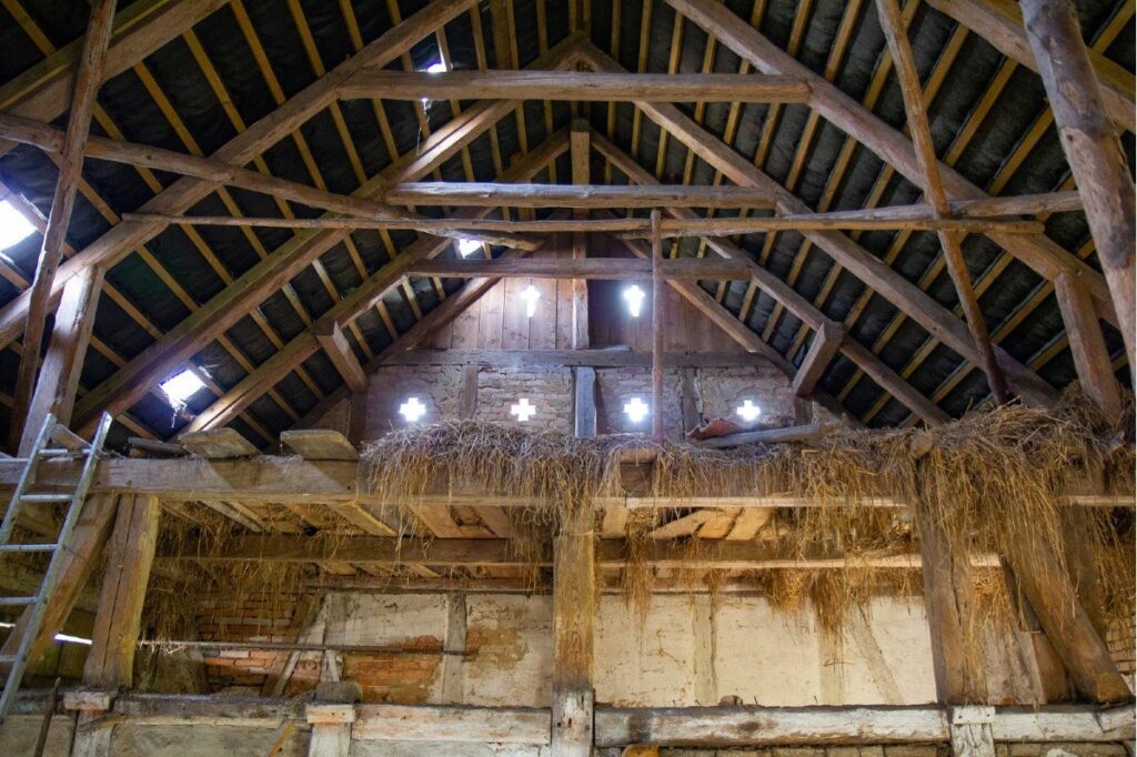 Scheune: Heuboden über der Dreschdiele vor Fachwerk-Südgiebelwand mit kreuzförmigen Lüftungsöffnungen