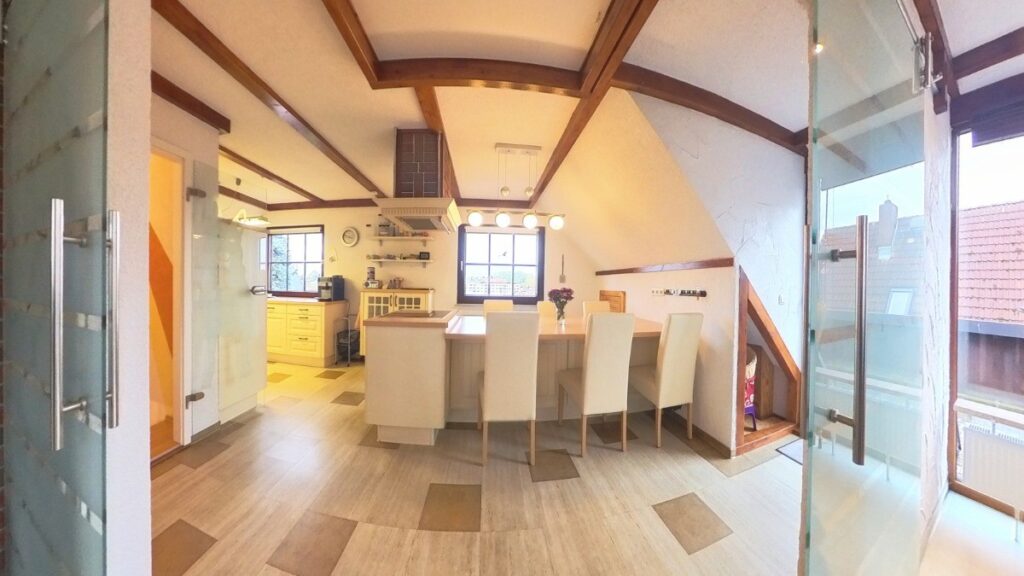 Blick in die Küche mit Kochinsel und Essbereich