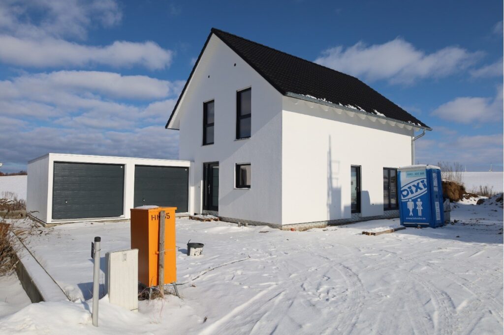 Südwestliche Perspektive auf das neu errichtete Wohnhaus mit Eingangsbereich