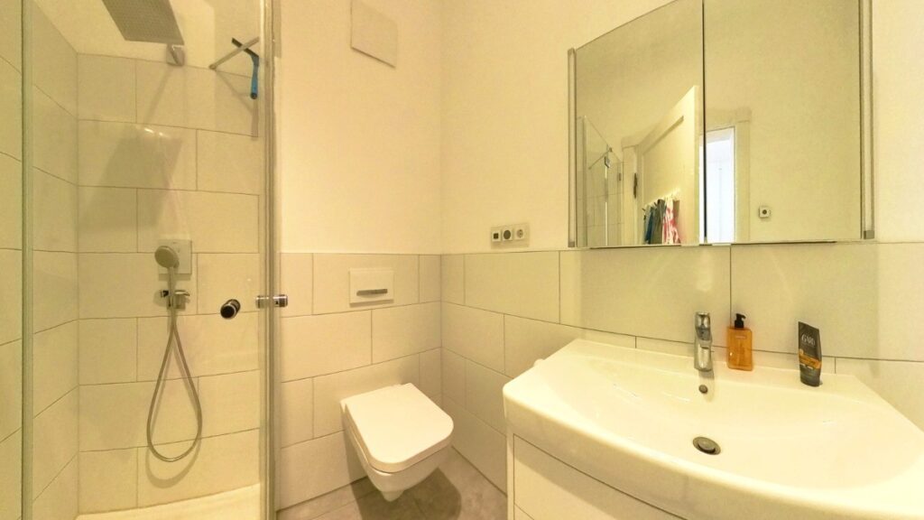 Helles Bad – ausgestattet mit Dusche, Wanne und Einbauradio