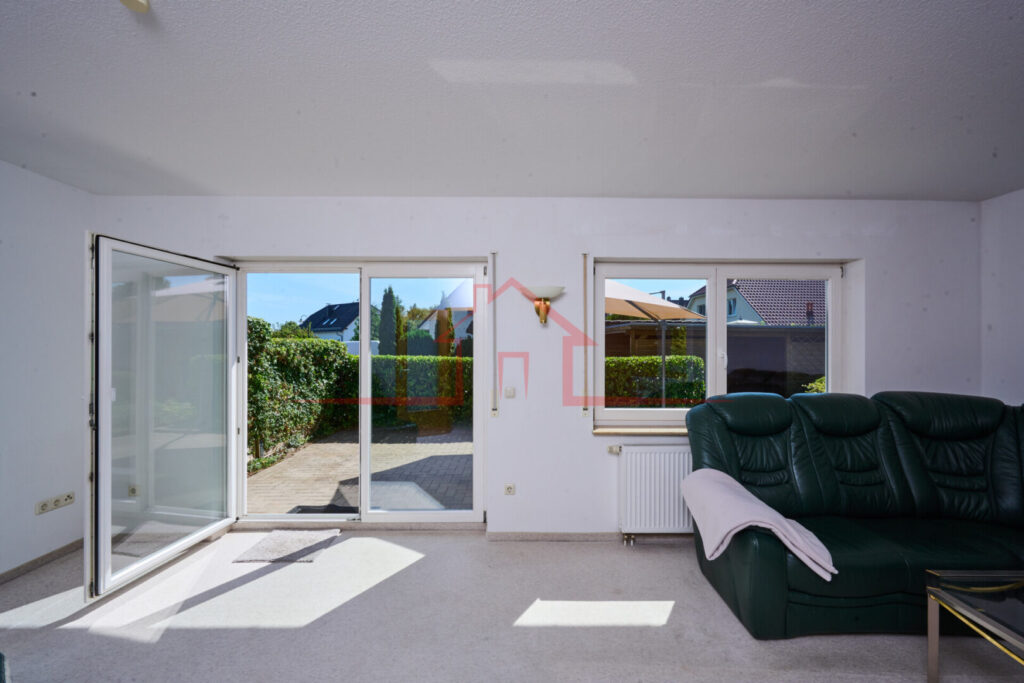 Blick in das helle und großzügige Wohnzimmer mit Zugang zur sonnigen Terrasse