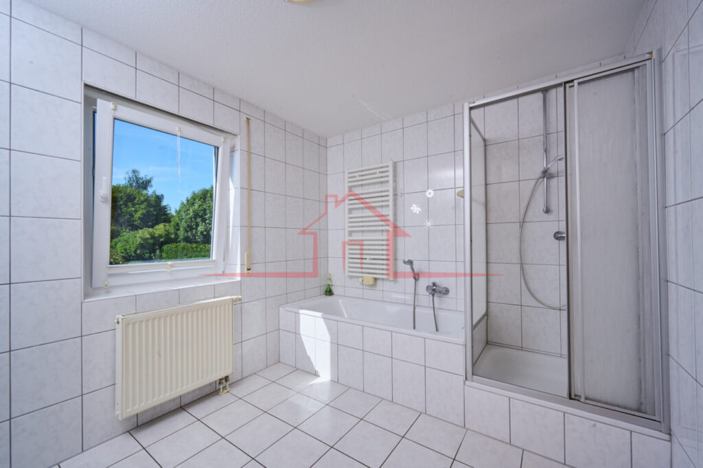 Blick in das helle Tageslichtbad mit Dusche und Badewanne