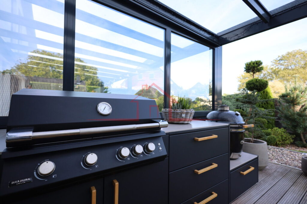Hochwertig ausgestatteter Outdoor-Kochbereich unter der überdachten Terrasse