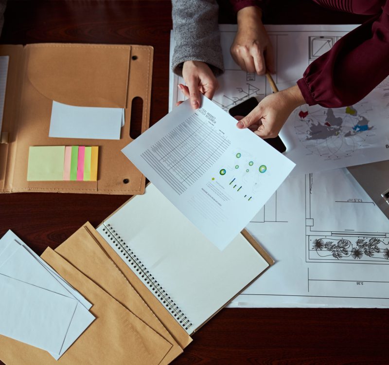 Professional designers working in modern office and making notes during active discussion