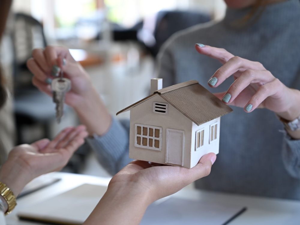 Cropped image of real estate agent offering home ownership to costumer.