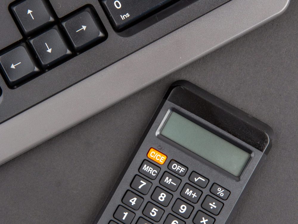 top view black office stuffs keyboard calculator on dark background